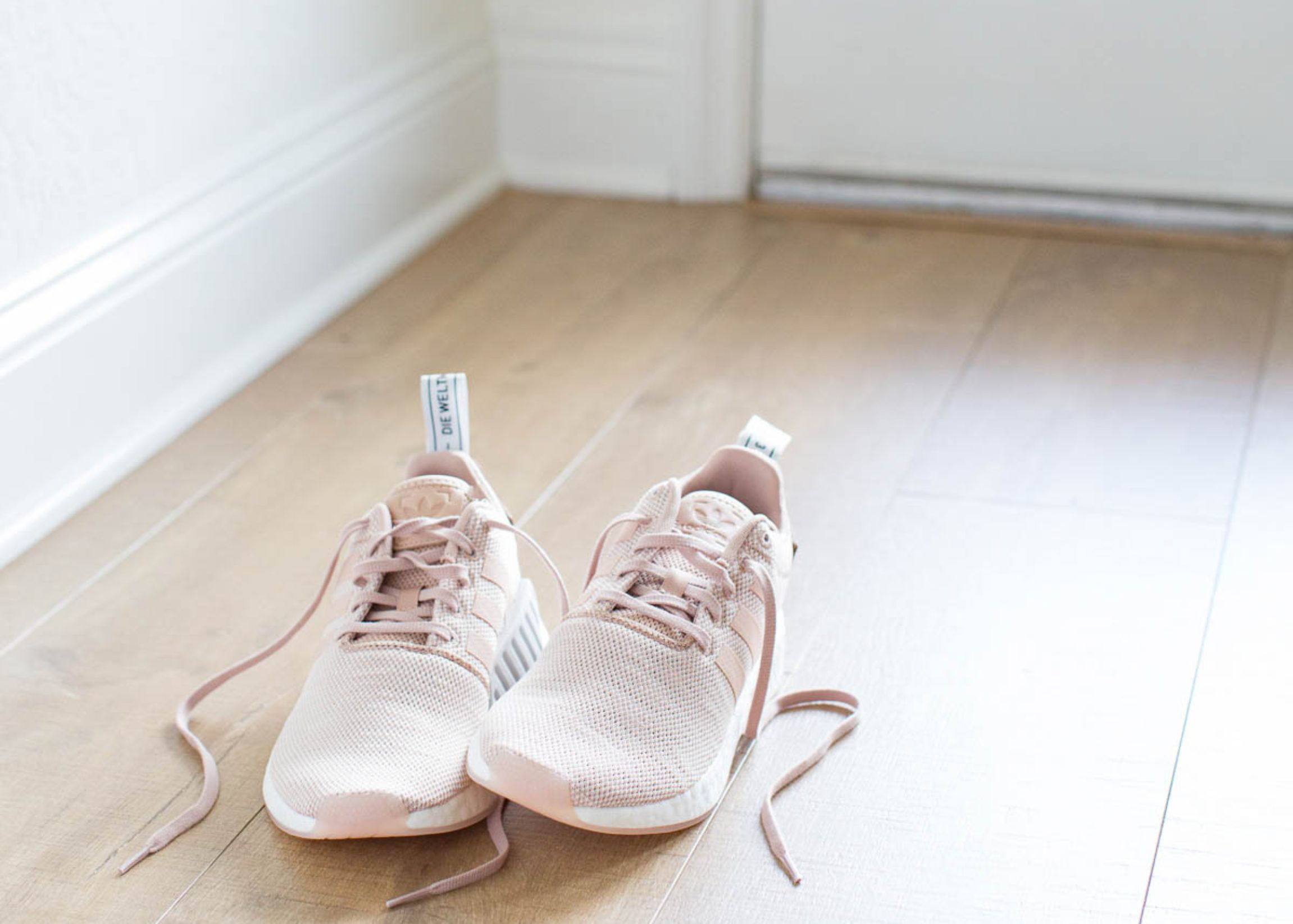 Running shoes on hardwood floor by door creating a visual cue to build better habits