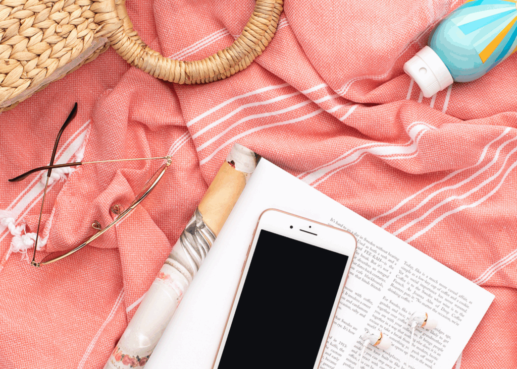 Beach towel with phone set aside showing mindful parenting and present moment connection